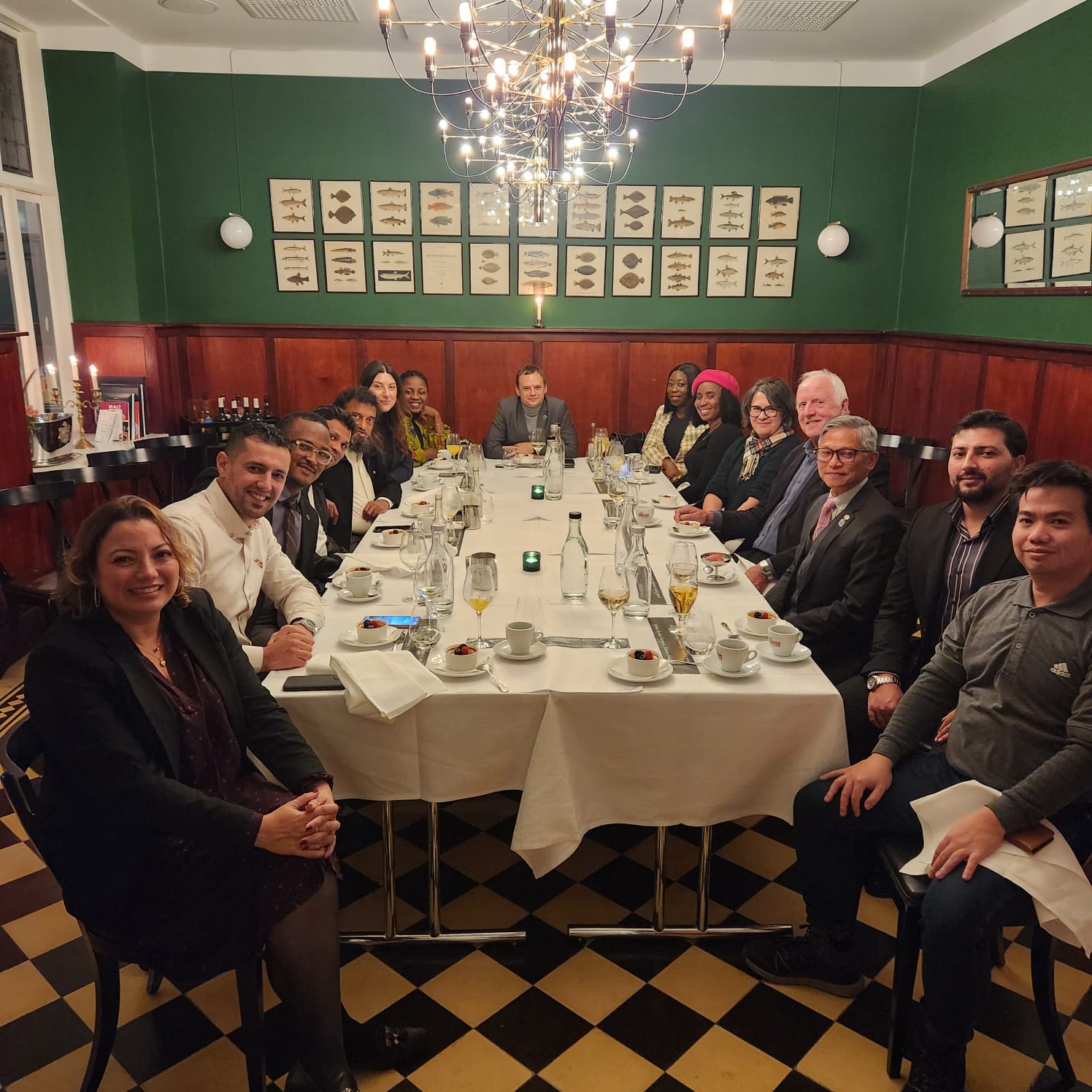 Class of 2023 and 2024 students seated around a dining table with Jacqueline Smith, Brian Orrell and Abdulgani Serang