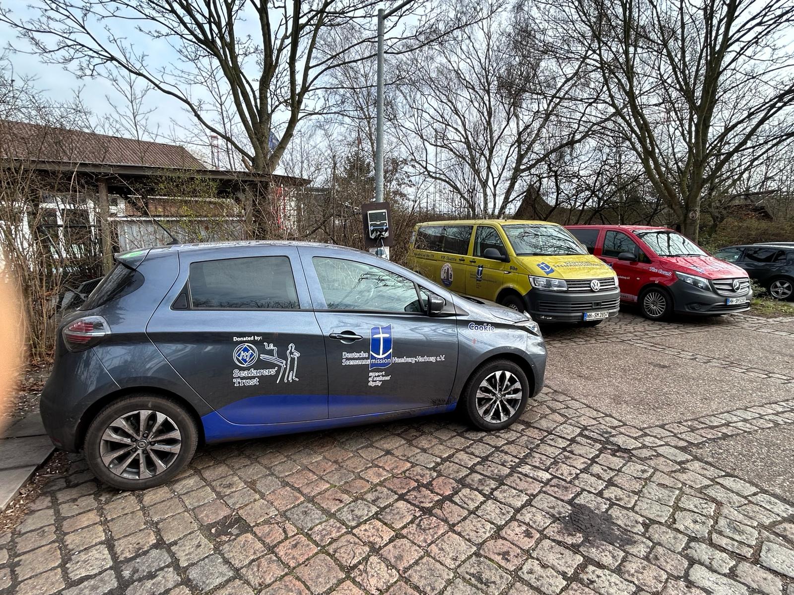 3 vehicles in the Duckdalben carpark. The vehicles display the Duckdalben and DSM logos and the logos of grant funders on the front and side panels.