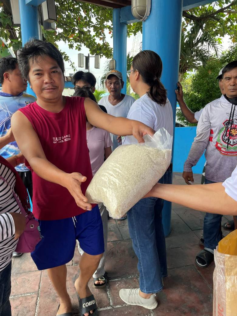 A person handing a bag of rice to another person

AI-generated content may be incorrect.